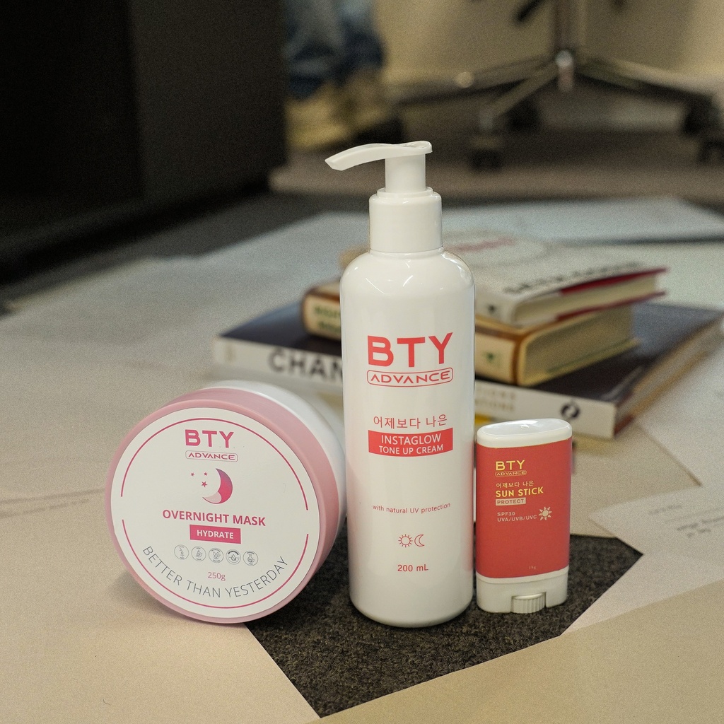 BTY Advance Overnight Mask, Instaglow, and Sun Stick on a desk with stacked books